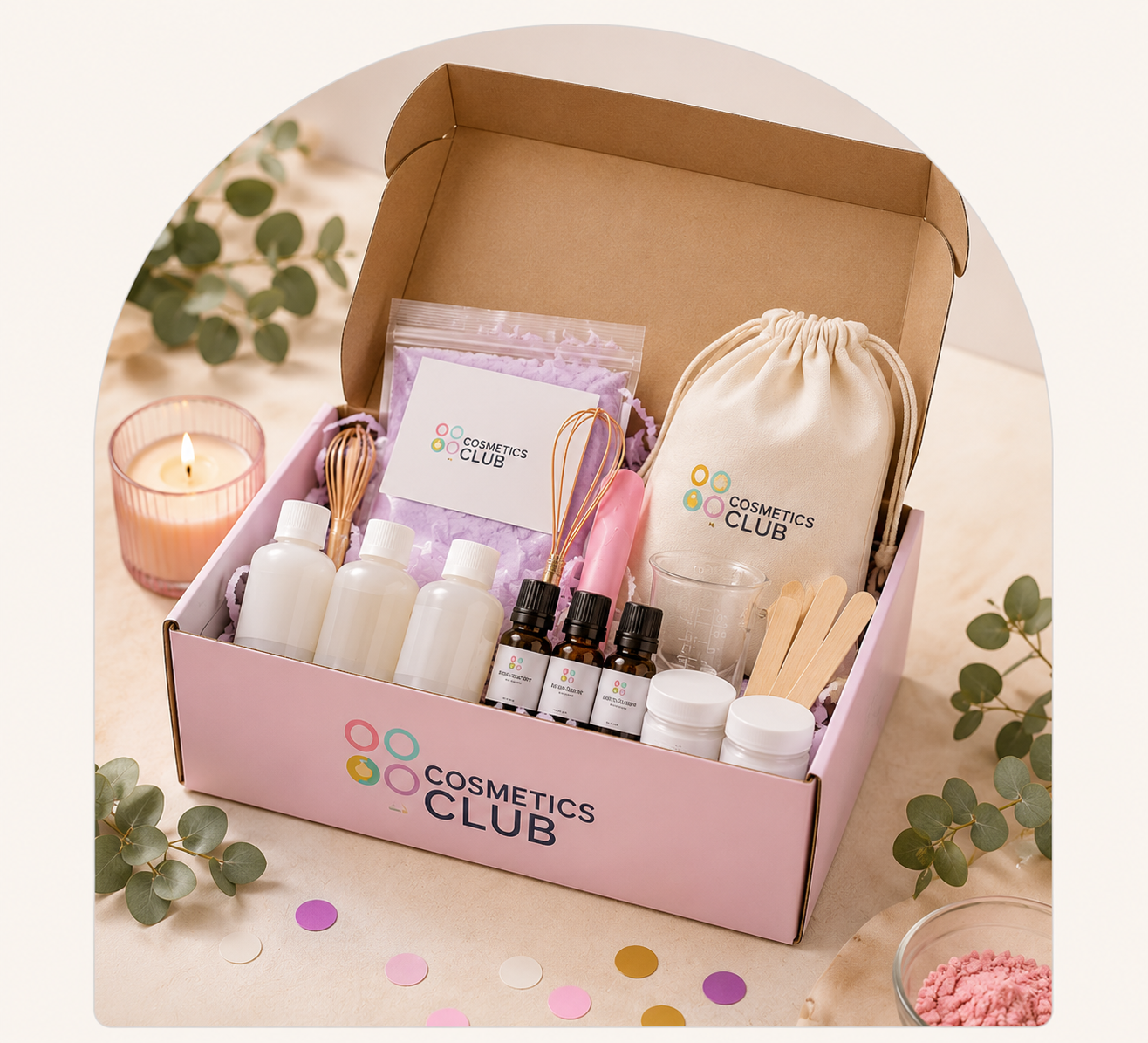 A Cosmetics Club Party-in-a-Box: pink branded box containing ingredient bottles, essential oils, whisks, a measuring cup, jars and a branded cotton bag